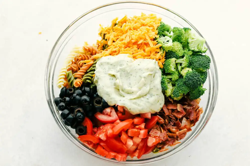 Bacon Ranch Pasta Salad ingredients in a clear bowl. - Incredible Bacon Ranch Pasta Salad