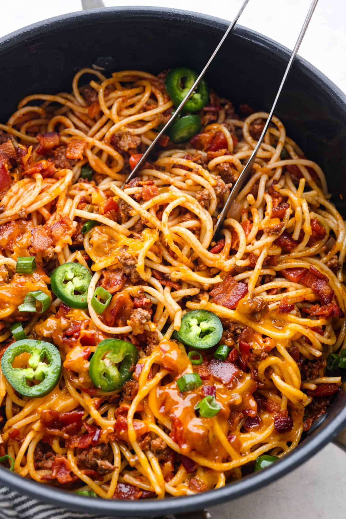 Spaghetti topped with shredded cheese, bacon, and jalapenos. - Cowboy Spaghetti