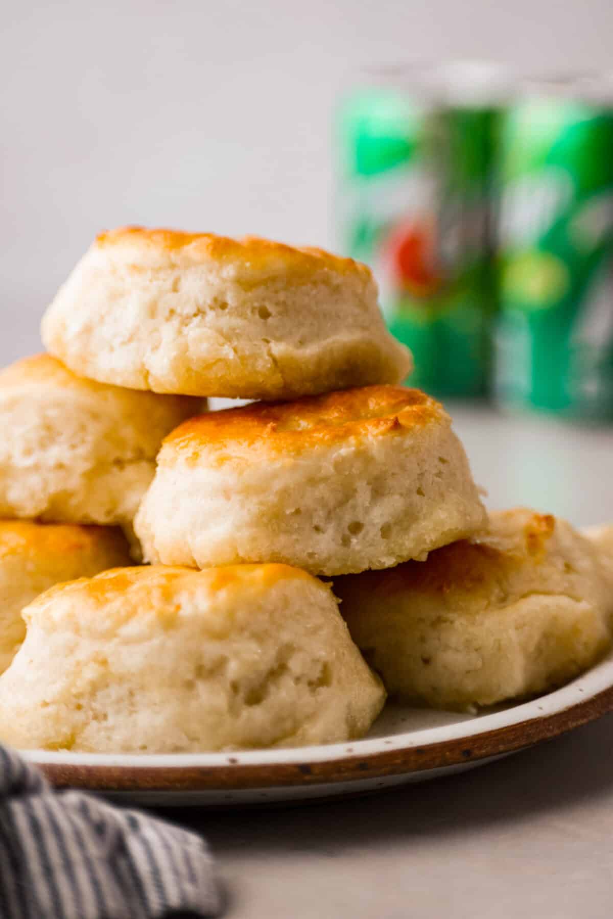 Close view of the 7 up biscuits stacked on a plate with 7 up in the back ground. - 7-Up Biscuits