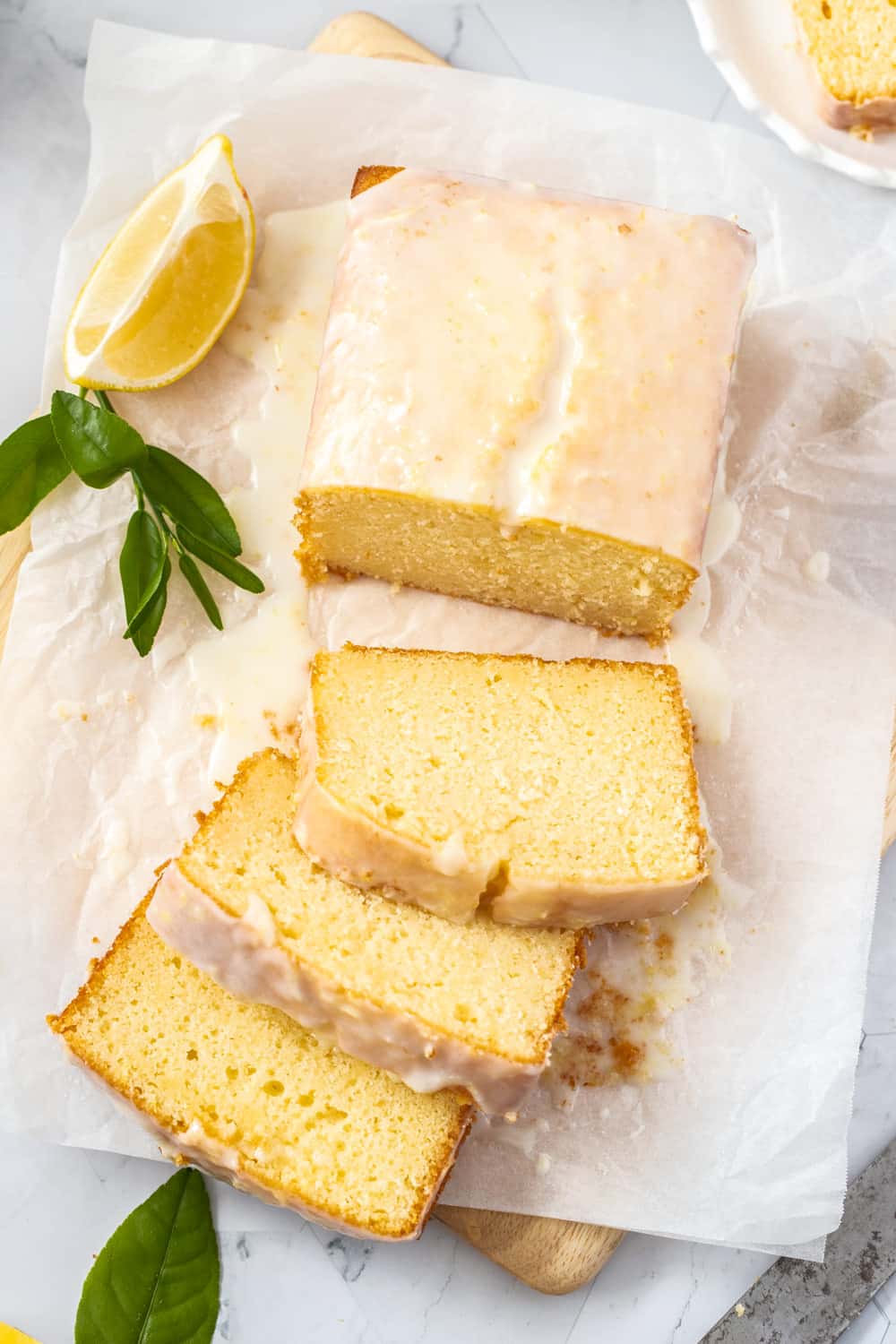 Birdseye view of a glazed cake on a sheet of baking paper. - Cream Cheese Pound Cake