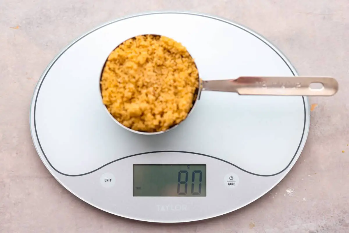 Unpacked brown sugar in a measuring cup on a scale. - How To Properly Measure Baking Ingredients