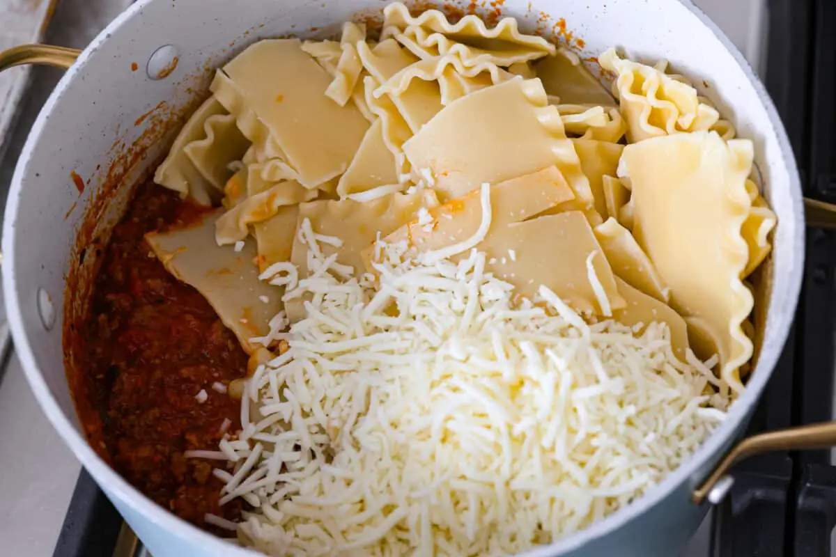 Noodles being added to a pot. - Easy Sheet Pan Lasagna