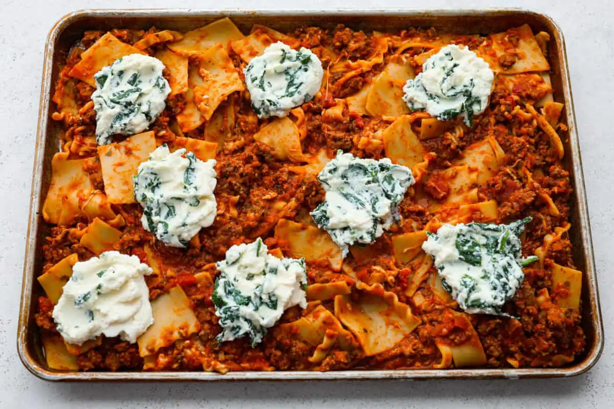 Dollops of spinach and ricotta on top of the noodles. - Easy Sheet Pan Lasagna