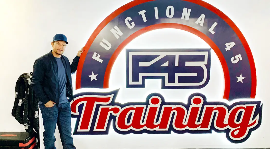 Mark-Whalberg-Standing-Next-To-F45-Sign - Why Is David Beckham Suing F45?