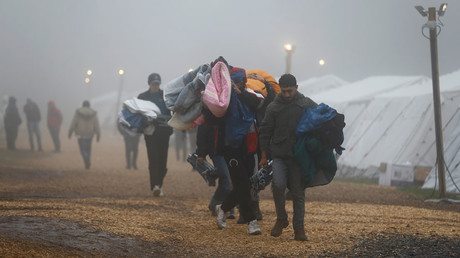 Migrants carry blankets and warm clothing at a temporary registration centre in the village of Schwarzenborn, northeast of Frankfurt, Germany © Kai Pfaffenbach - Asylum Seekers Scam German Aid Program For Millions By Applying With ‘up To 12’ Fake IDs — RT News