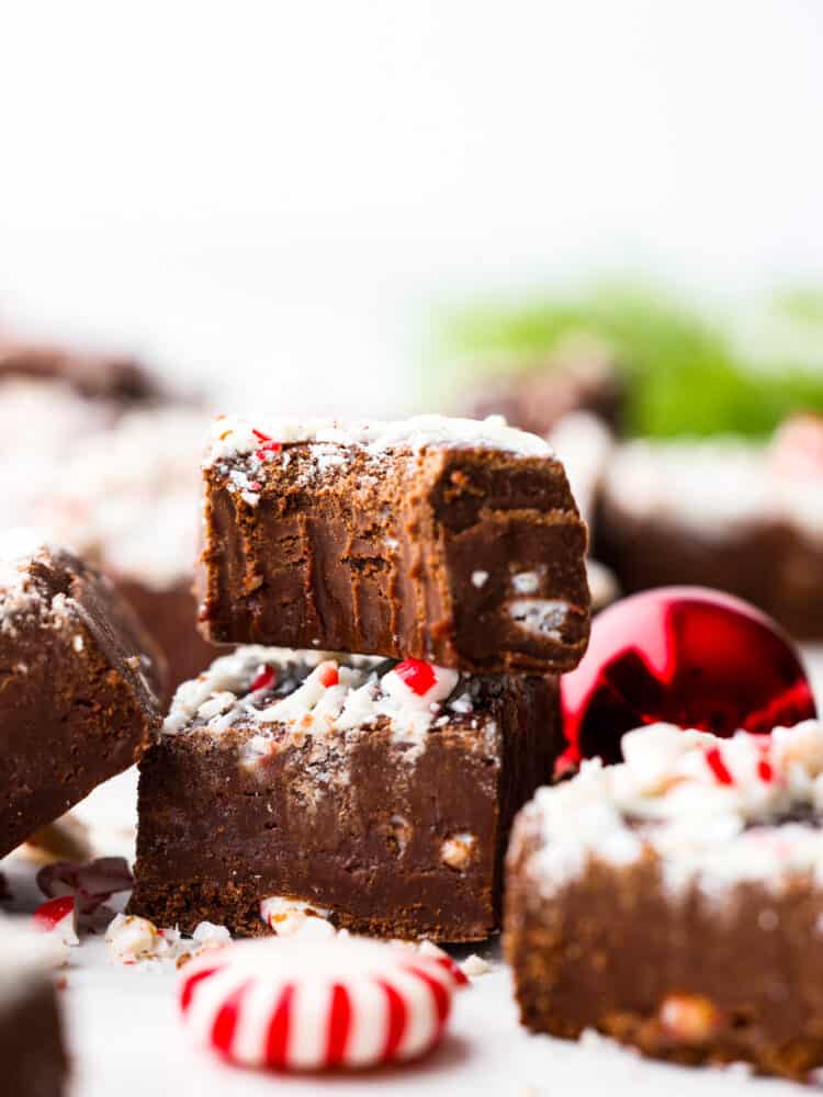 Peppermint fudge stacked on top of each other, one with a bite taken out of it. - Chocolate Peppermint Fudge