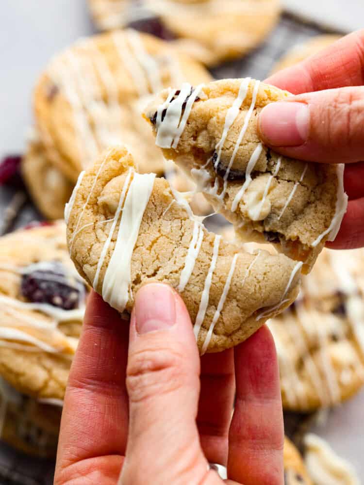A cookie being broken apart. - White Chocolate Cherry Cranberry Cookies