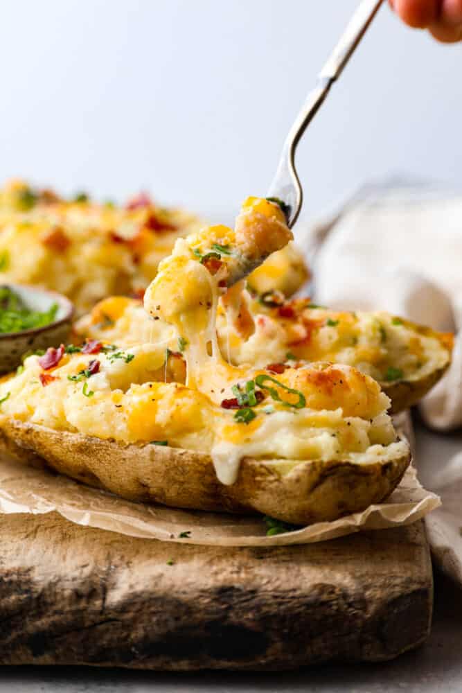 Taking a bite of a twice baked potato with a fork. - Twice Baked Potatoes