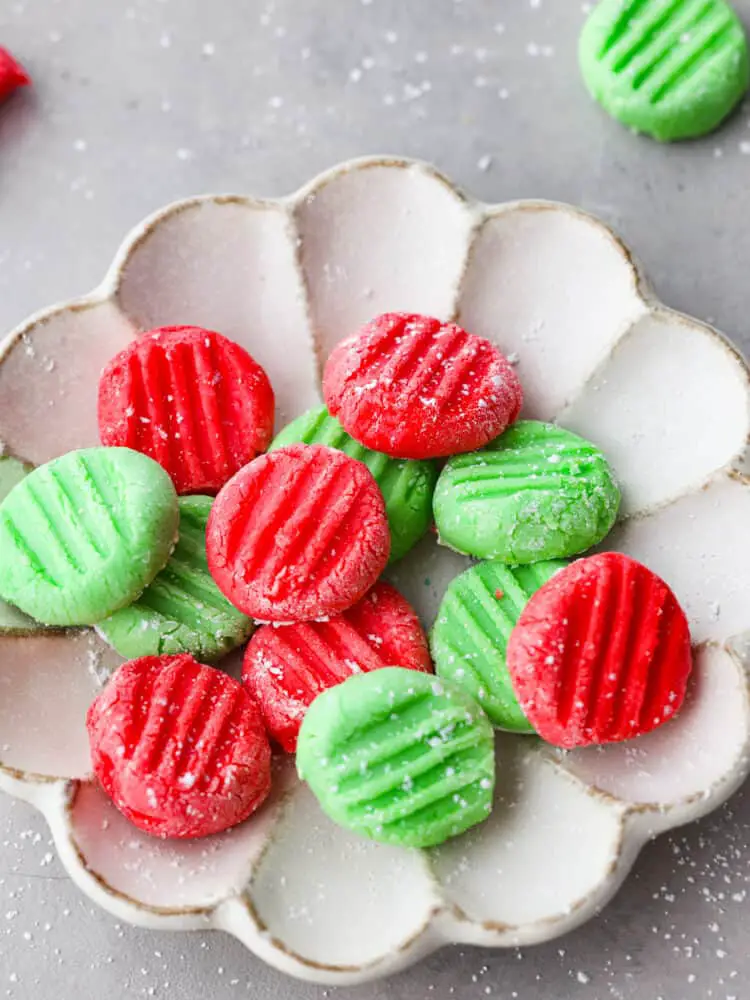 A close up of the red and green mints in a scalloped dish. - Cream Cheese Mints