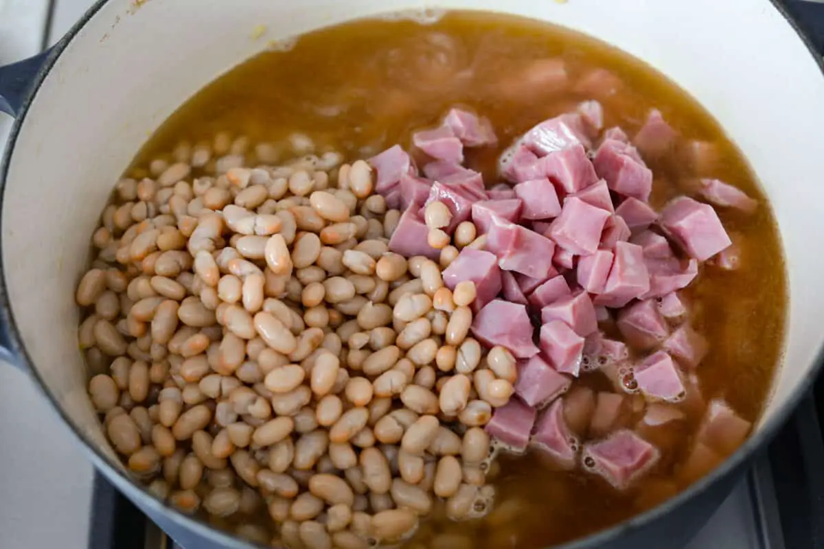 Third process photo of the beans and ham added to the pot. - Ham And Bean Soup