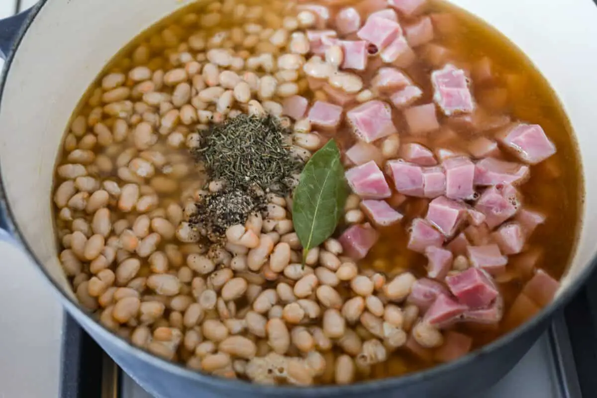 Fourth process photo of the bay leaf, pepper, and thyme added to the pot. - Ham And Bean Soup