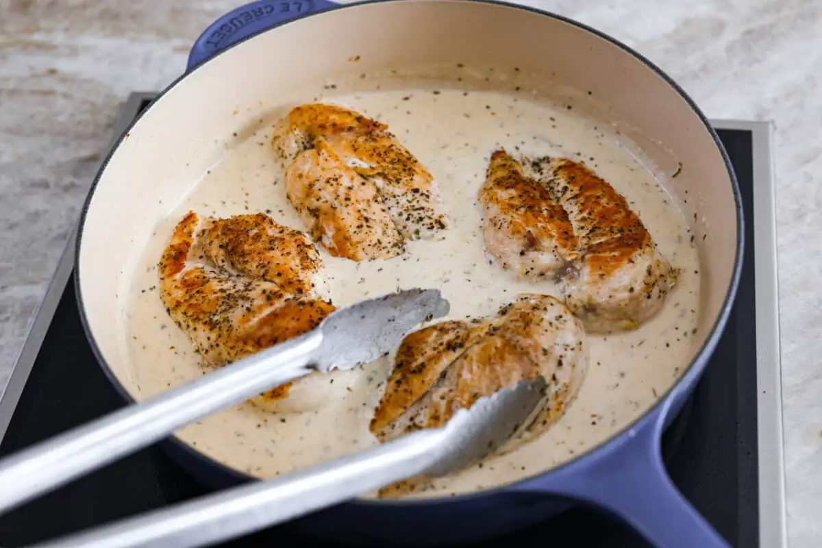 Combining the sauce with the cooked chicken. - Creamy Lemon Parmesan Chicken