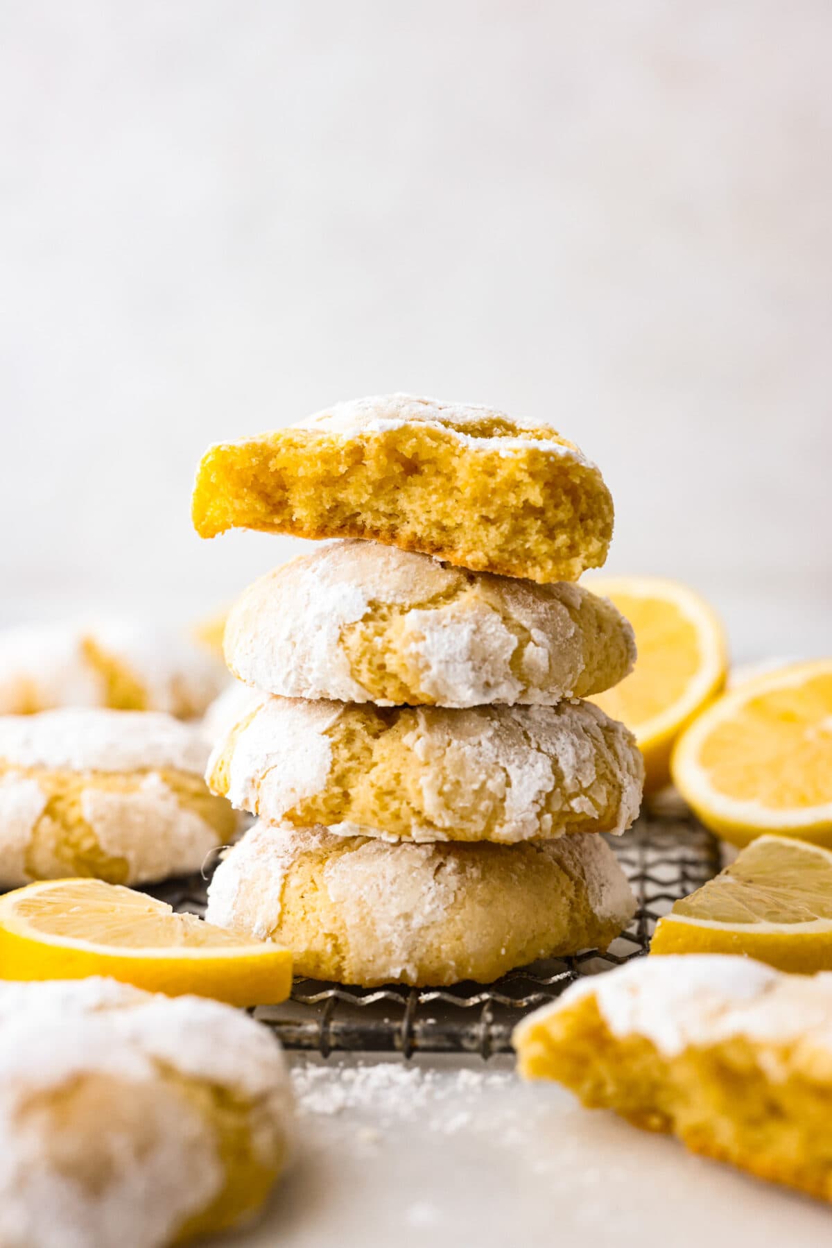 4 cookies stacked on top of each other. One is broken in half. - Lemon Crinkle Cookies