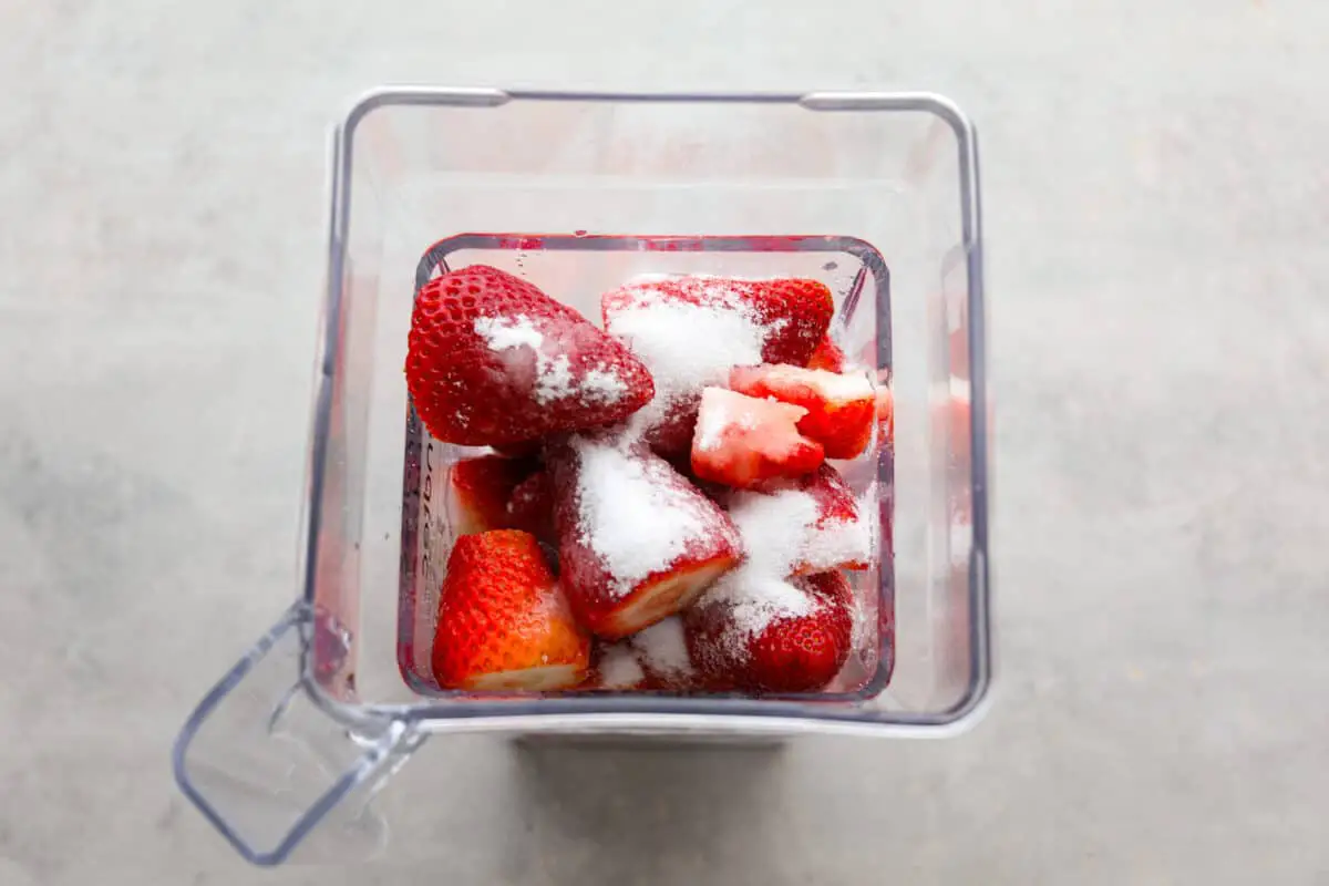 Process photo of the strawberries, sugar, and lemon juice added to a blender. - Strawberry Horchata